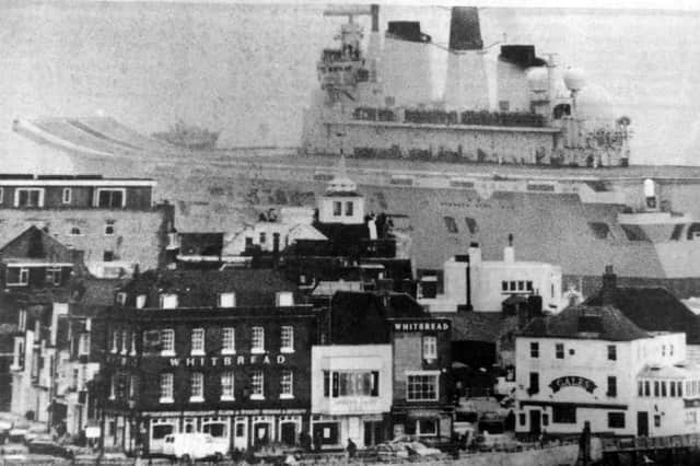 HMS Ark Royal sails into the Solent dwarfing buildings at Point, Old Portsmouth.
