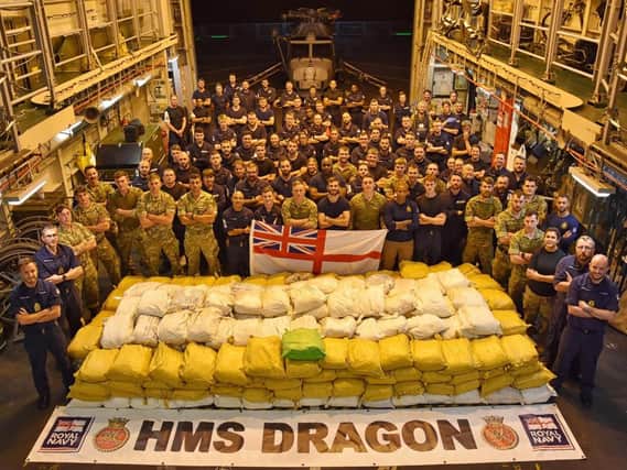 HMS Dragon's ship's company pose with the haul of drugs they seized towards the end of last year. Photo: Royal Navy