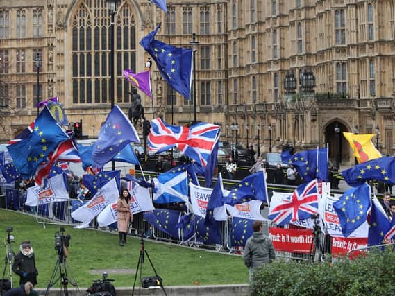 Anti-Brexit and Pro-Brexit protesters fly flags outside the Houses of Parliament, London, ahead of the House of Commons vote on the Prime Minister's Brexit deal. Picture: Yui Mok/PA Wire