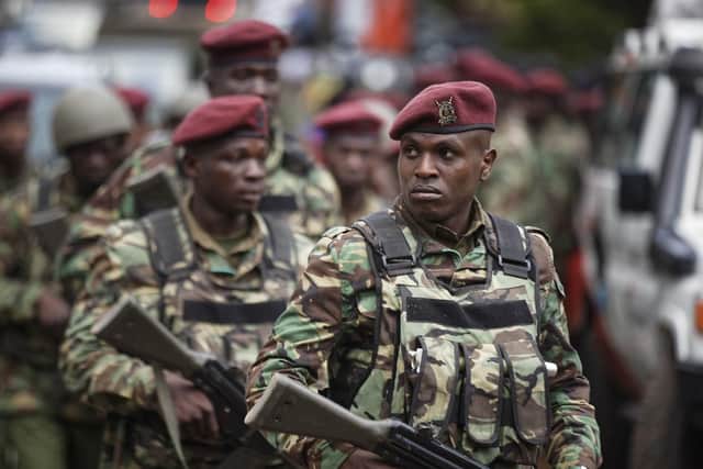 Kenyan security forces walk from the scene as continued blasts and gunfire could be heard early Wednesday, Jan. 16, 2019, in Nairobi, Kenya. Extremists stormed a luxury hotel in Kenya's capital on Tuesday, setting off thunderous explosions and gunning down people at cafe tables in an attack claimed by Africa's deadliest Islamic militant group. (AP Photo/Ben Curtis)