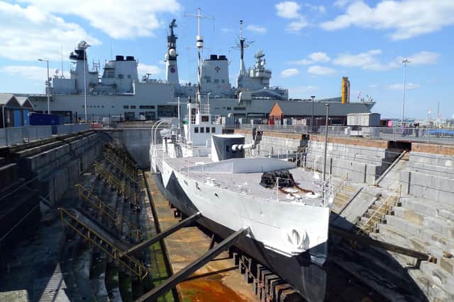 Ancient and modern. First World War monitor HMS M33, restored with her original Dazzle outlines, lies in No1 dry dock in Portsmouth Historic Dockyard. HMS Illustrious in the background was later scrapped. Picture: Tim King.