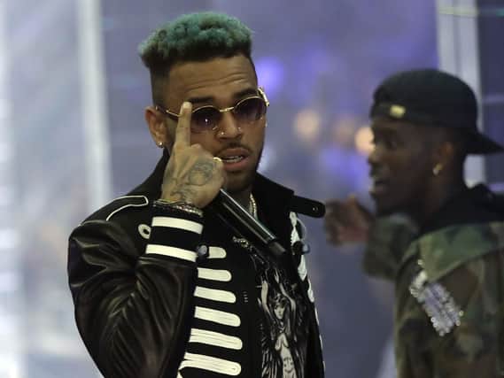 Police officials say U.S. singer Chris Brown and two other people are in custody in Paris after a woman filed a rape complaint. Picture: AP Photo/Luca Bruno, File