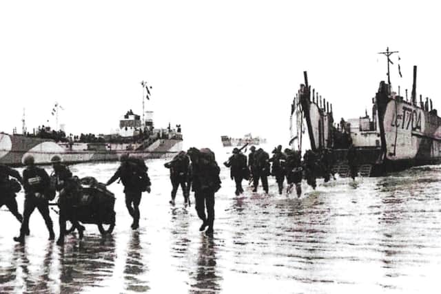Troops march off a Landing Craft Tank (LCT) 704 at Fox Red beach, Hayling