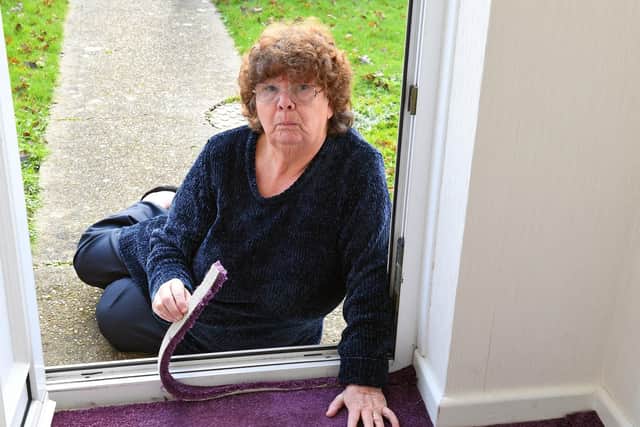 Joan Haiselden with the carpet that she bought from SCS in Waterlooville which was badly fitted in the porch way area at her Havant home Picture by: Malcolm Wells (190123-2627)