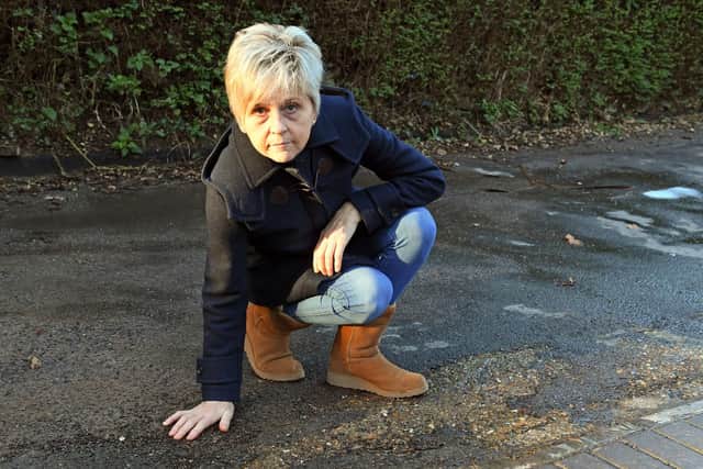 Carol Pritchard is appalled at the workmanship of a local company when they laid a new top surface to the access road at her home Picture by: Malcolm Wells (190123-2692)