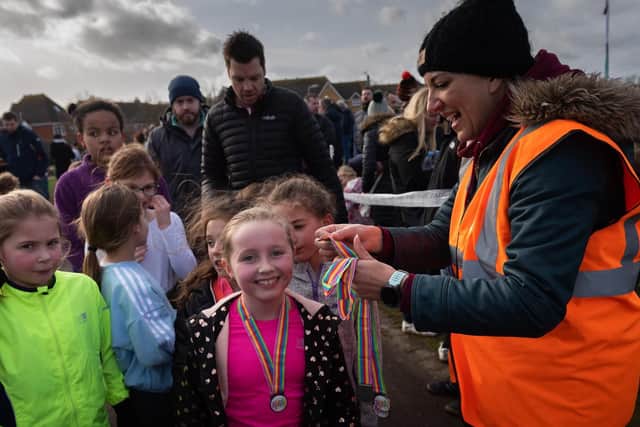 Runners at the Whiteley Fun Run at the Meadowside Leisure Centre get a medal as they cross the finish line. Picture: Vernon Nash (090219-063)