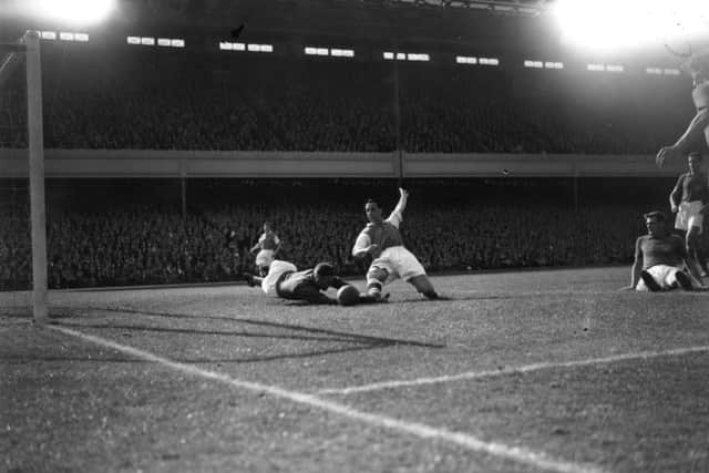September 17 1955:  Arsenal striker Tommy Lawton competes for the ball with Pompey goalkeeper, Uprichard, at Highbury. PPP-190802-152029003