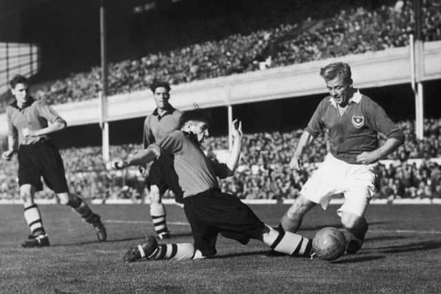 Wolves centre half Bill Shorthouse makes a sliding tackle on Pompey's Jack Froggatt during the FA Charity Shield match at Highbury Stadium, London, on October 19 1949. PPP-190802-150342003