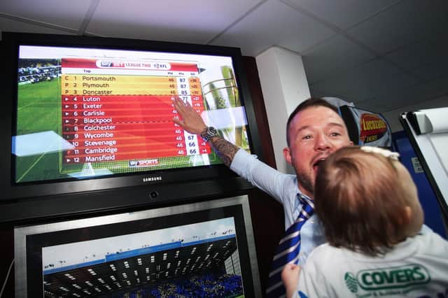 Noel Hunt looks at the League Two table after Pompey won the title. Picture: Joe Pepler