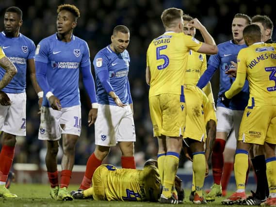 Arms are raised between James Vaughan of Portsmouth FC and Tom Lockyer of Bristol Rovers and Lockyer hits the floor during the Sky Bet League 1 match between Portsmouth and Bristol Rovers at Fratton Park, Portsmouth, England on 19 February 2019. Photo by Robin Jones/Digital South.