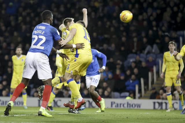 James Clarke heads past his own keeper under pressure from Omar Bogle as Pompey equalise. Picture: Robin Jones/Digital South