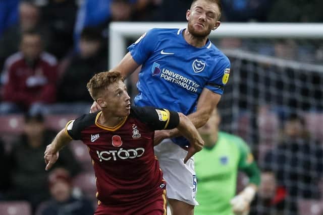Matt Clarke overcomes former Pompey team-mate Eoin Doyle at Valley Parade during the club's previous encounter in November. Picture: Daniel Chesterton/phcimages.com/PinPep