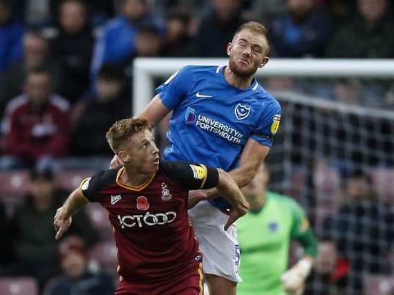 Matt Clarke overcomes former Pompey team-mate Eoin Doyle at Valley Parade during the club's previous encounter in November. Picture: Daniel Chesterton/phcimages.com/PinPep