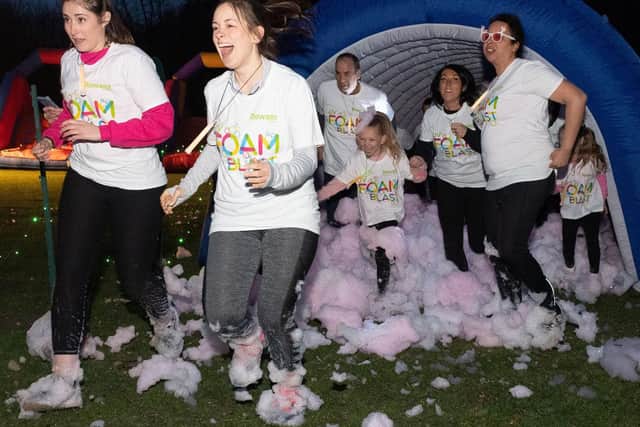 Participants emerge from the foam tunnel.
Picture: Keith Woodland (090319-37)