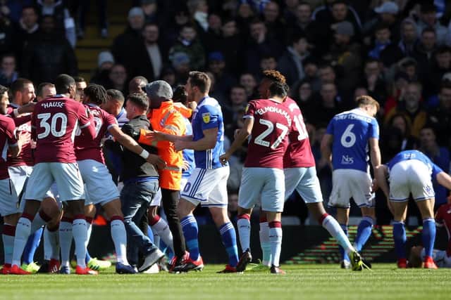 Paul Mitchell being restrained after attacking Aston Villa's Jack Grealish on the pitch (right) during the Sky Bet Championship match at St Andrew's. Picture: Nick Potts/PA Wire