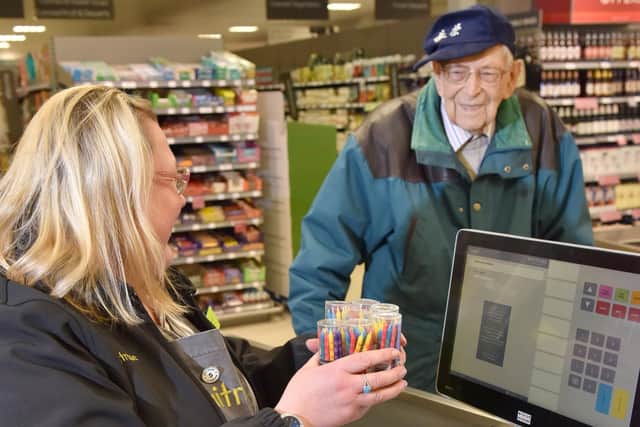 Waitrose staff member Clare Wilks helps Bob scan his birthday candles at the till. Picture: Morten Watkins/Solent News & Pho