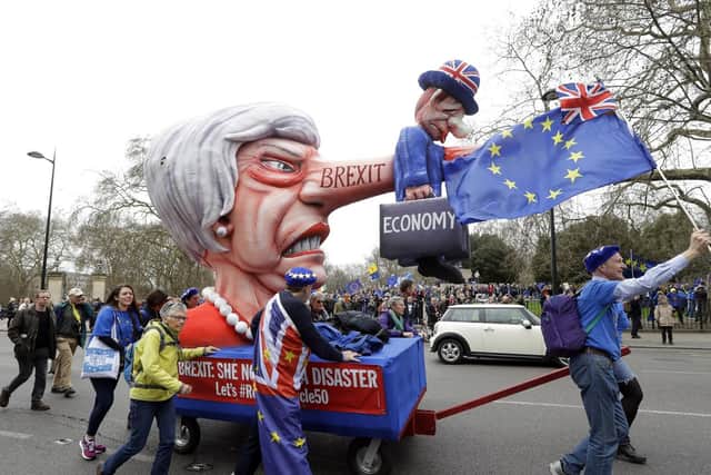 Demonstrators pull a cart with a doll resembling British Prime Minister Theresa May during a Peoples Vote anti-Brexit march in London on March 23. Picture: AP Photo/Kirsty Wigglesworth