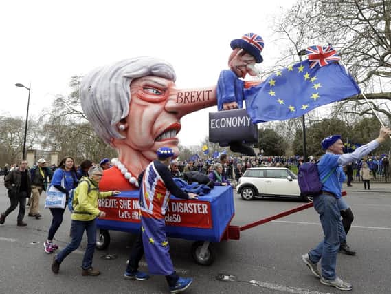 Demonstrators pull a cart with a doll resembling British Prime Minister Theresa May during a Peoples Vote anti-Brexit march in London on March 23. Picture: AP Photo/Kirsty Wigglesworth