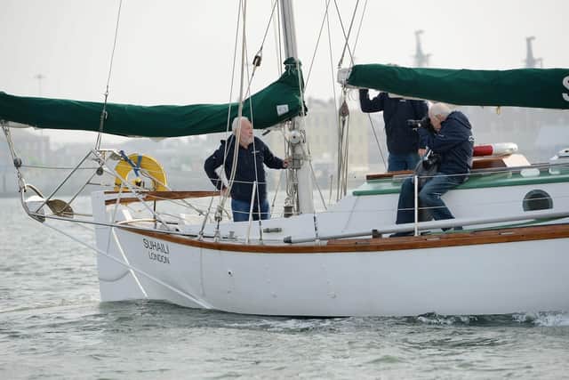 Sir Robin poses at the tiller of Suhaili for photographer Bill Rowntree as he sails out of Portsmouth Harbour this morning. Picture: Morten Watkins/Solent News & Photo Agency