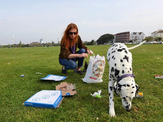 Yvette Davis and her Dalmatian Lola collect rubbish including pizza boxes on Southsea Common this morning. Photo: Morten Watkins/Solent News & Photo Agency