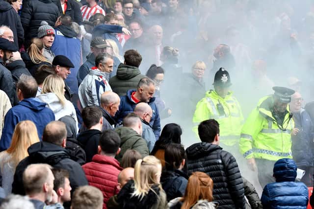 A flare thrown lands in a section of Sunderland supporters. Picture by Frank Reid