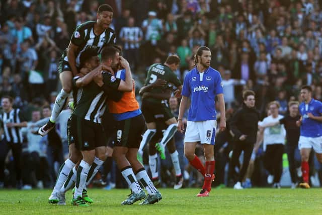 Christian Burgess cuts a dejected figure as Plymouth's players and fans celebrate on the Home Park pitch in the play-off semi-final second leg in May 2016. Picture: Joe Pepler