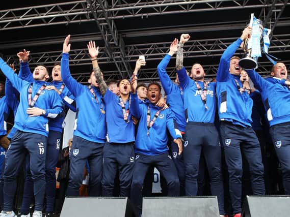 Michael Doyle lifts the League Two trophy as Pompey celebrate the title win. Picture: Joe Pepler