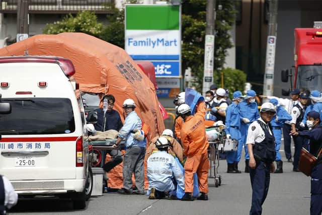 Rescuers work at the scene of an attack in Kawasaki, near Tokyo Tuesday, May 28, 2019. A man wielding a knife attacked commuters waiting at a bus stop just outside Tokyo during Tuesday morning's rush hour,  Japanese authorities and media said. (Kyodo News via AP)