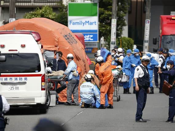 Rescuers work at the scene of an attack in Kawasaki, near Tokyo Tuesday, May 28, 2019. A man wielding a knife attacked commuters waiting at a bus stop just outside Tokyo during Tuesday morning's rush hour,  Japanese authorities and media said. (Kyodo News via AP)