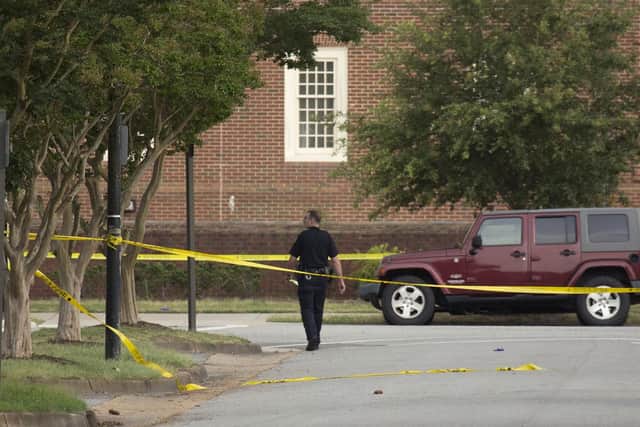 A police officer walks at the scene where twelve people were killed during a mass shooting at the Virginia Beach city public works building, Friday, May 31, 2019 in Virginia Beach, Va. Picture (L. Todd Spencer/The Virginian-Pilot via AP)