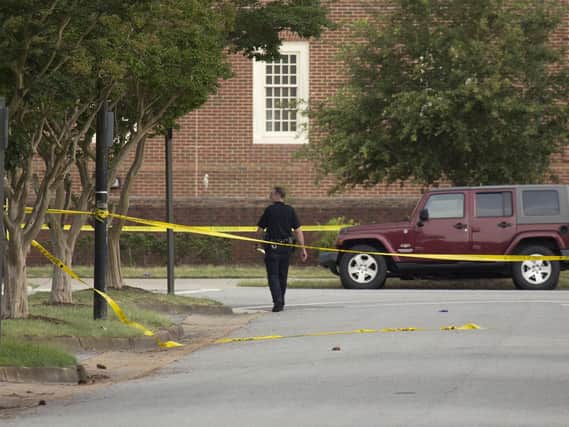 A police officer walks at the scene where twelve people were killed during a mass shooting at the Virginia Beach city public works building, Friday, May 31, 2019 in Virginia Beach, Va. Picture (L. Todd Spencer/The Virginian-Pilot via AP)