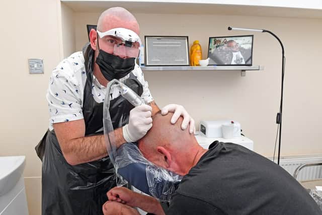 Andrew Styles - the owner of 'Black Velvet' based at 'Mendusa' in Osborne Road, Southsea, Hampshire performing a highly-skilled procedure of Scalp Micro-pigmentation on Thomas Baxter . Picture: Malcolm Wells (190613-2647)