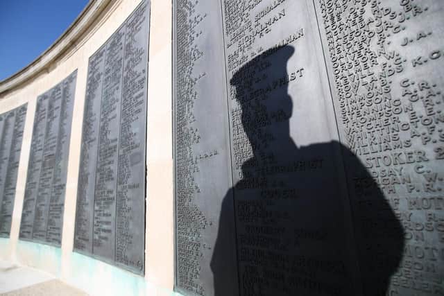 The shadow of a Royal Navy rating falls on the names on one of the panels on the Portsmouth Naval memorial in Southsea. Picture: Andrew Matthews/PA Wire