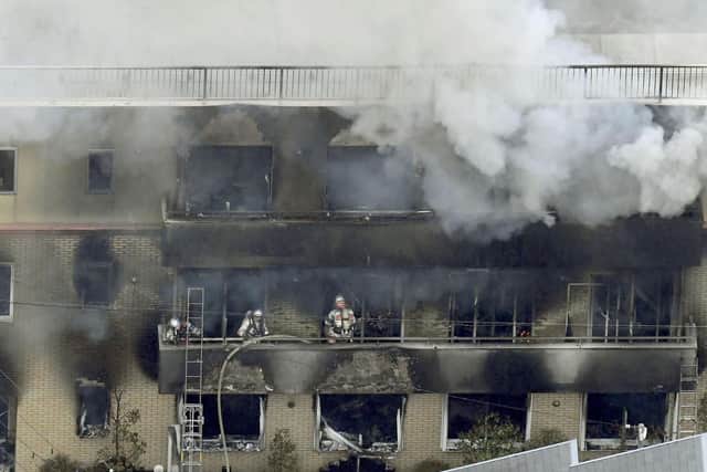 Firefighters work as smoke billows from a three-story building of Kyoto Animation in a fire in Kyoto, western Japan, Thursday, July 18, 2019. Kyoto prefectural police said the fire broke out Thursday morning after a man burst into it and spread unidentified liquid and put fire. Picture: Kyodo News via AP
