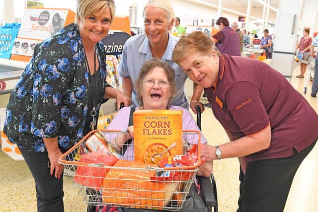 Kath Glanville does her shopping in style at Sainsbury's Farlington store with, from left, online manager Janie Essery, Vonda Thorne from Hilsea Lodge and customer assistant Linda Tyler. Picture: Malcolm Wells (190724-4712)