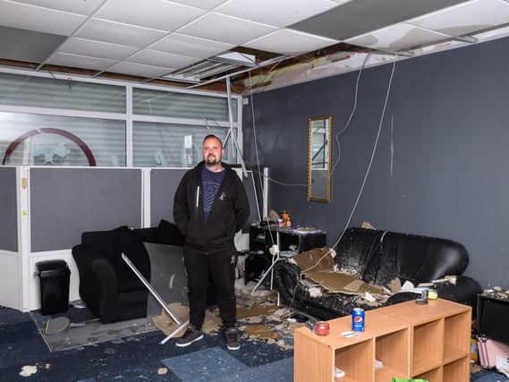 Pictured is: Danny Silvester amongst the damage caused to his tattoo parlour by the fire in the above flat.

Picture: Keith Woodland (270719-4)