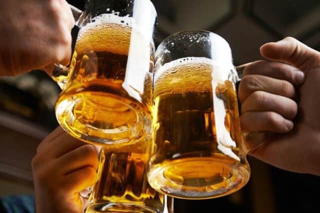 Hands of three men toasting with beer