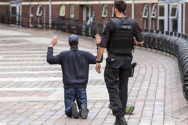 A Hampshire armed police officer detains a male near the Crown Court in Portsmouth, Hampshire. Picture: Steve Parsons/PA Wire