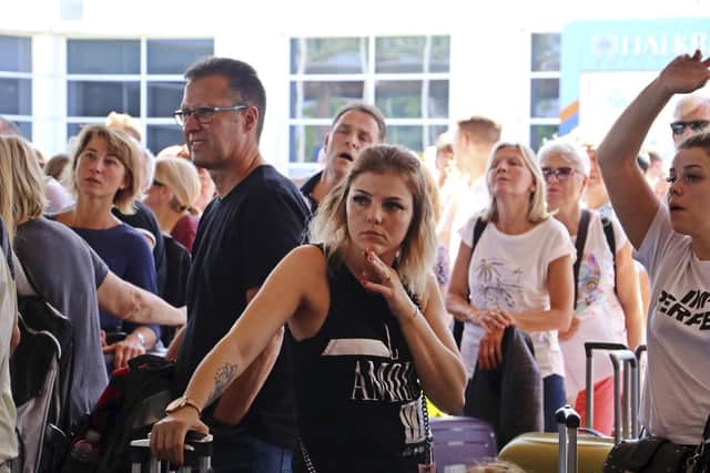 British passengers with Thomas Cook wait in queue at Antalya airport in Antalya, Turkey, Monday Sept. 23, 2019. Hundreds of thousands of travellers were stranded across the world Monday after British tour company Thomas Cook collapsed, immediately halting almost all its flights and hotel services and laying off all its employees. According to reports Monday morning some 21,000 Thomas Cook travellers were stranded in Turkey alone.(IHA via AP)