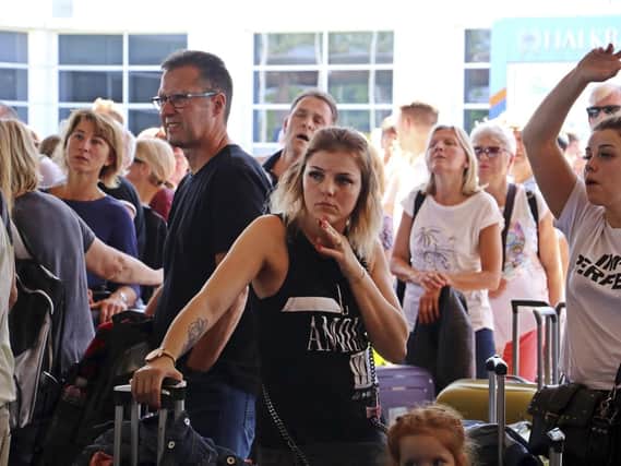 British passengers with Thomas Cook wait in queue at Antalya airport in Antalya, Turkey, Monday Sept. 23, 2019. Hundreds of thousands of travellers were stranded across the world Monday after British tour company Thomas Cook collapsed, immediately halting almost all its flights and hotel services and laying off all its employees. According to reports Monday morning some 21,000 Thomas Cook travellers were stranded in Turkey alone.(IHA via AP)