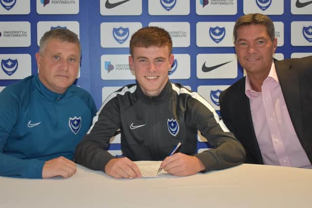Harvey Rew signs his first professional deal at Pompey alongside Mark Kelly, left, and Mark Catlin, right. Picture: Portsmouth FC