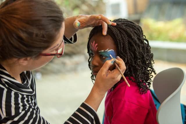 Michelle Mendy, 5, has her face painted by Irene Gandara Moral from 'In Your Face' at the African-Caribbean Fusion Festival at the University of Portsmouth's Eldon building Picture: Vernon Nash (051019-010)