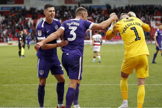 James Bolton, left, and Lee Brown, centre, celebrate with Craig MacGillivray following Pompey's win at Doncaster. Picture: Daniel Chesterton/PinPep