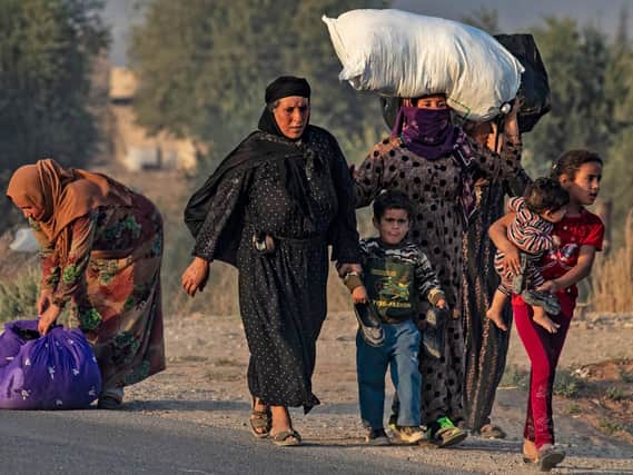 Syrian Arab and Kurdish civilians flee amid Turkish bombardment on Syria's northeastern town of Ras al-Ain in the Hasakeh province along the Turkish border on October 9, 2019.  Photo: Delil SouleimanAFP via Getty Images
