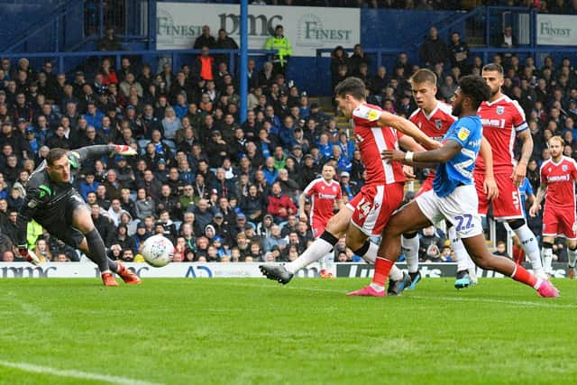 Thomas O'Connor of Gillingham puts the ball behind as Ellis Harrison closes in