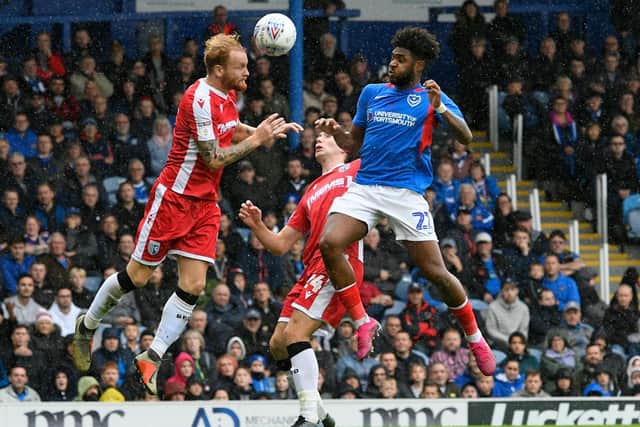Ellis Harrison in an aerial duel with Gillingham's Connor Ogilvie