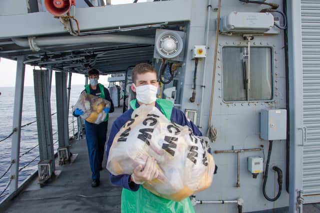 Montrose sailors carrying bags of drugs they seized from a dhow boat.