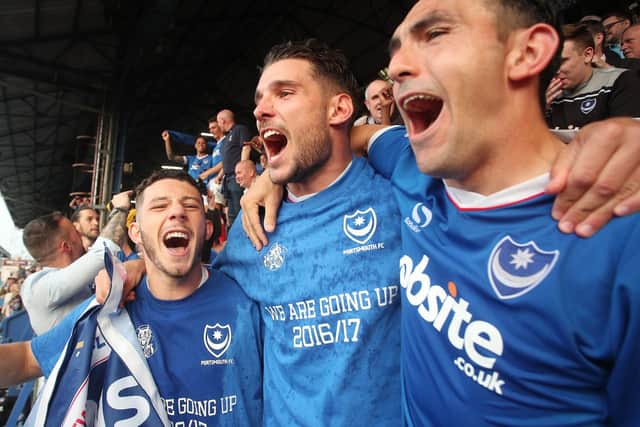 Gareth Evans, centre, celebrates Pompey's League Two title triumph with Conor Chaplin, left, and Gary Roberts. Picture: Joe Pepler