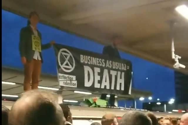 Picture taken with permission from the Twitter feed of @ChrisChrysanth2 showing Extinction Rebellion protesters on the roof of an Underground train surrounded by angry commuters at Canning Town station in east London. Photo credit: @ChrisChrysanth2/PA Wire