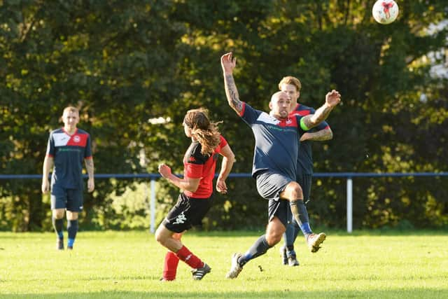 Paulsgrove midfielder Arron Fennemore goes past Bush Hill skipper James Lavender